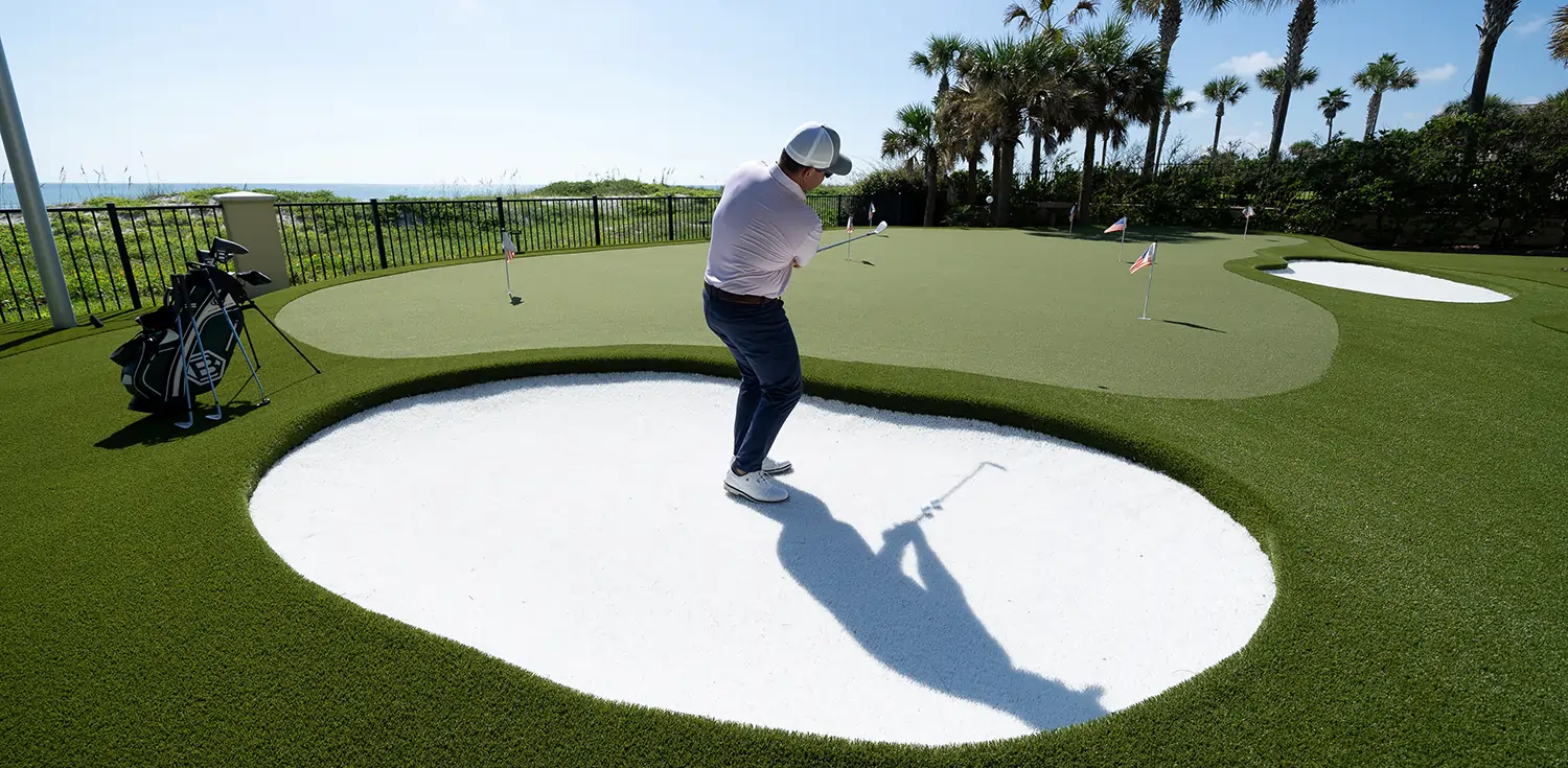 Golfer practicing backyard golf green